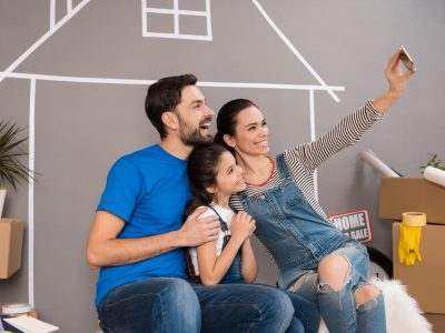Concept of house selling. Happy family sells house.